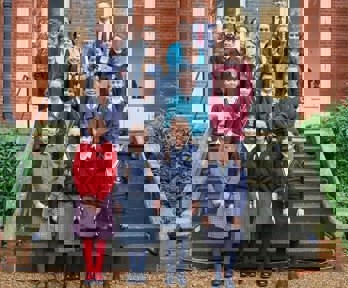 A selection of students who have won the Young Geographer of the Year competition standing on the steps of the Royal Geographical Society