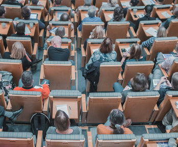 High-angle photograph of an audience seated in a modern lecture hall.