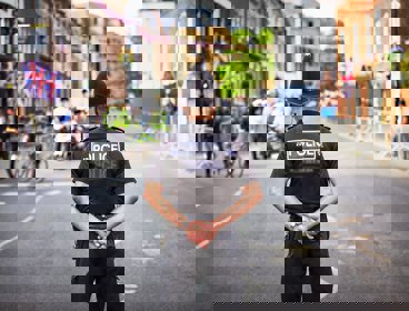 A policeman with his back to camera on a city street