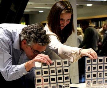Two people looking at slides in folders.