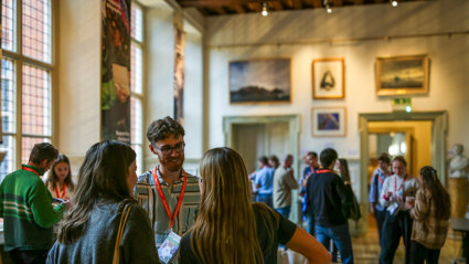 Conference attendees networking in the Main Hall at the Royal Geographical Society.