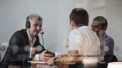 Two people interviewing a person wearing a headset.