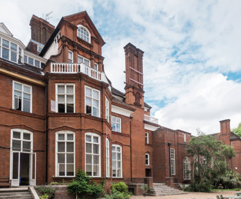 Rear view of the red-brick Royal Geographical Society building from the back terrace, featuring classic architectural details.