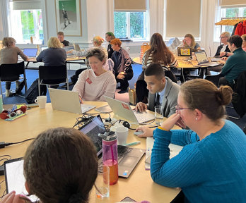 People sitting at tables looking at laptops