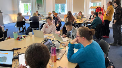 People sitting at tables looking at laptops