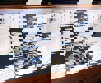 Display of historic materials from Royal Geographical Society collections, including books, printed labels, and glass lantern slides