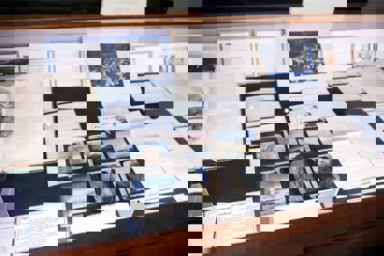 Display of historic materials from Royal Geographical Society collections, including books, printed labels, and glass lantern slides