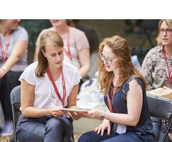 Two women looking at a notebook